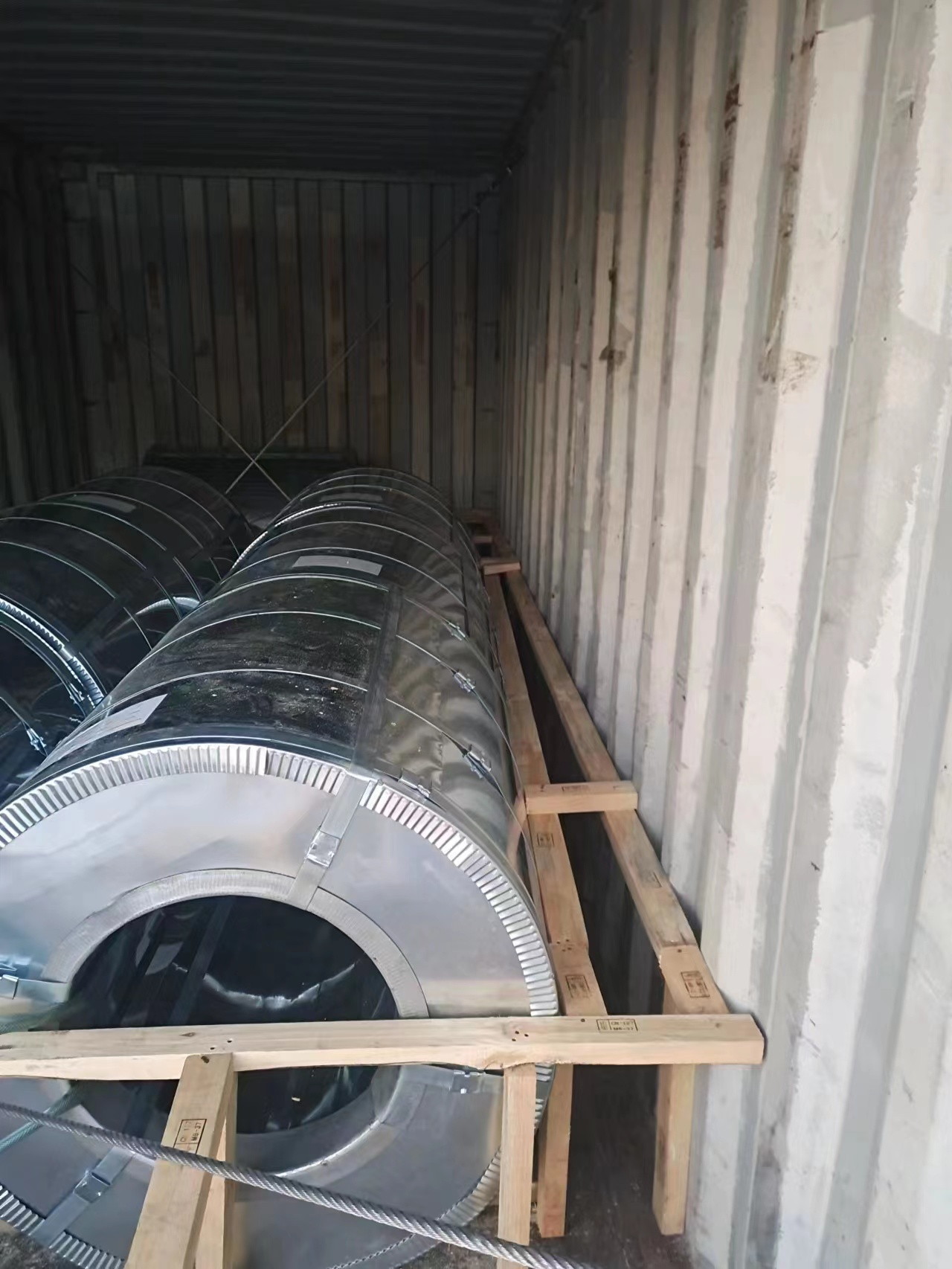 Loaded container interior with coils and strapping checked